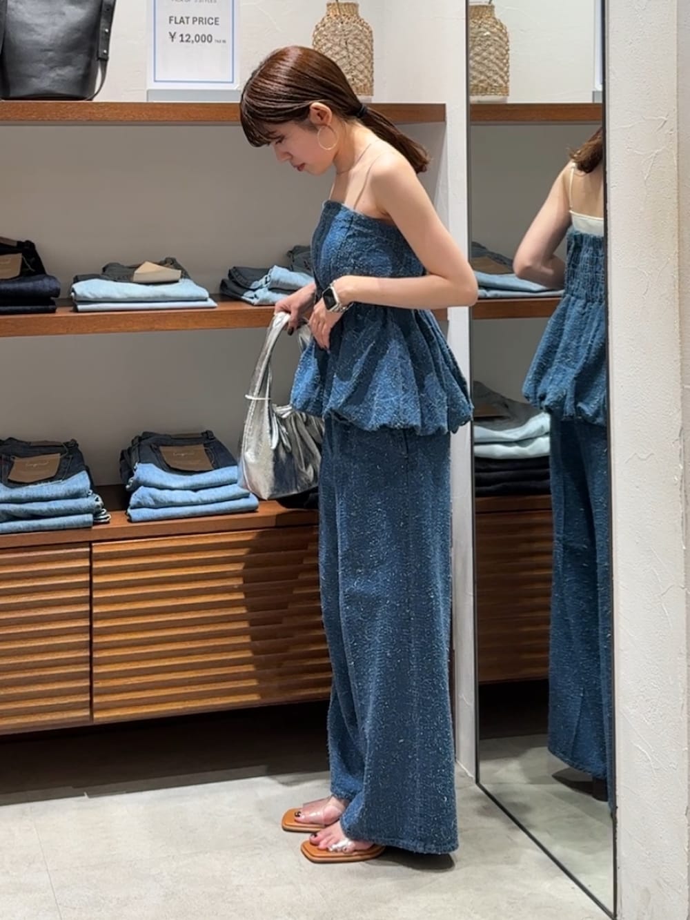 ブルー系のチューブトップ、ブルー系のデニムパンツ、その他のサンダルを着用したレディースの春コーディネートの7枚目の写真
