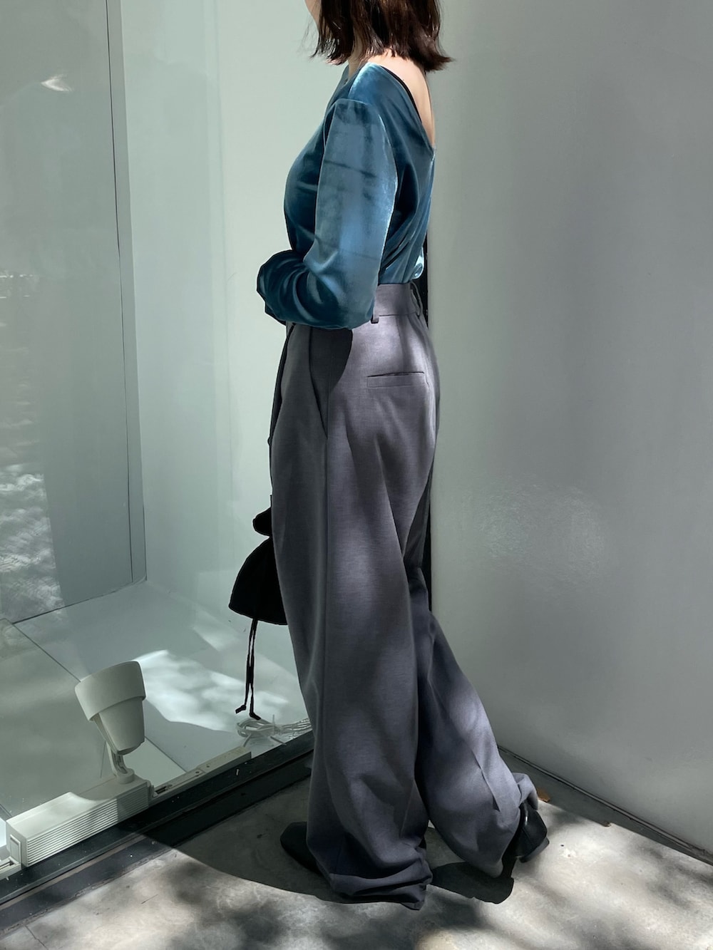 ブラック系のブーツ、ブラック系のハンドバッグ、ブルー系のTシャツ/カットソーを着用したレディースの秋コーディネートの3枚目の写真