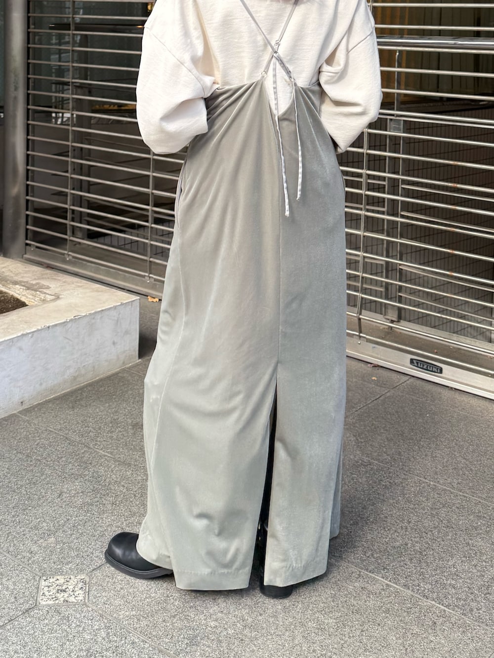 グレー系のワンピース、ホワイト系のスウェット、ブラック系のブーツを着用したレディースの冬コーディネートの6枚目の写真