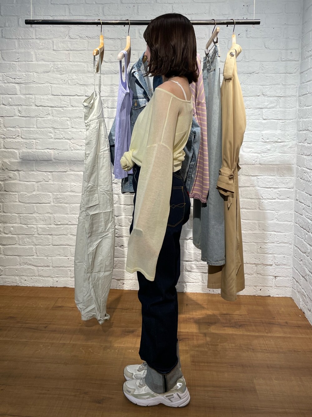 イエロー系のニット/セーター、ブルー系のデニムパンツを着用したレディースの春コーディネートの3枚目の写真