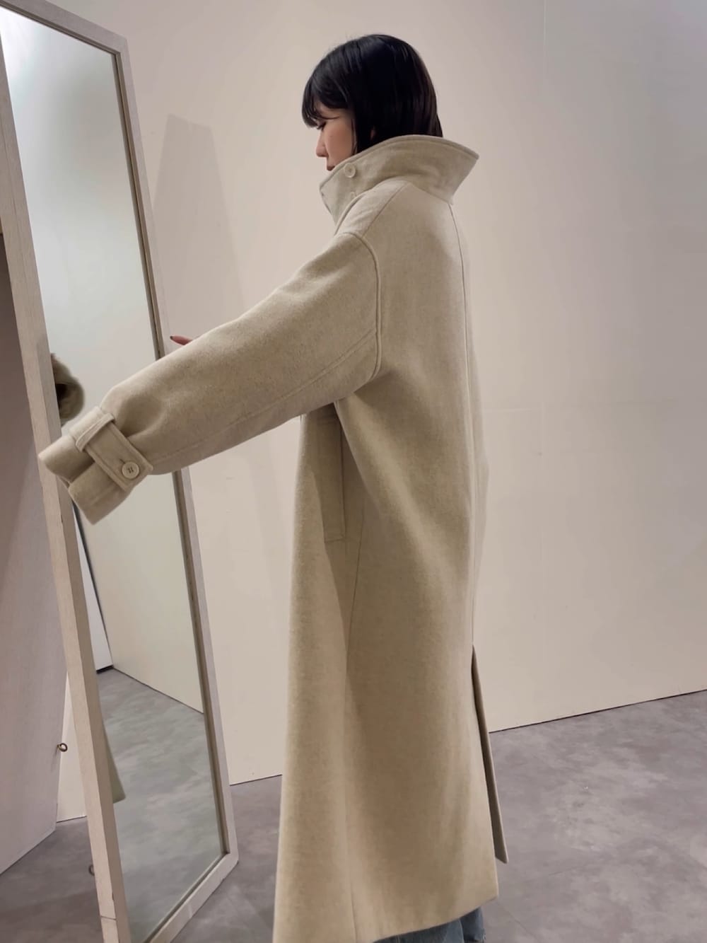 ブルー系のデニムパンツ、ブラック系のブーツ、レッド系のニット/セーターを着用したレディースの冬コーディネートの7枚目の写真