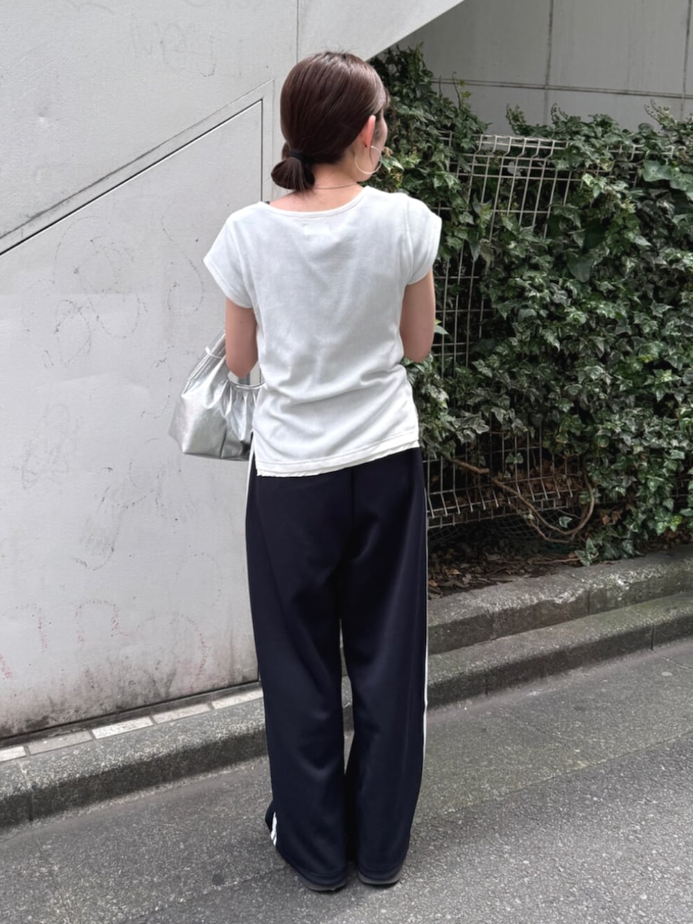 シルバー系のハンドバッグ、ブルー系のその他パンツ、ホワイト系のTシャツ/カットソーを着用したレディースの夏コーディネートの3枚目の写真