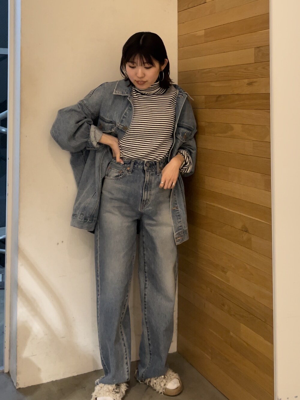 ホワイト系のサンダル、ホワイト系のニット/セーター、ブルー系のデニムジャケットを着用したレディースの春コーディネートの2枚目の写真