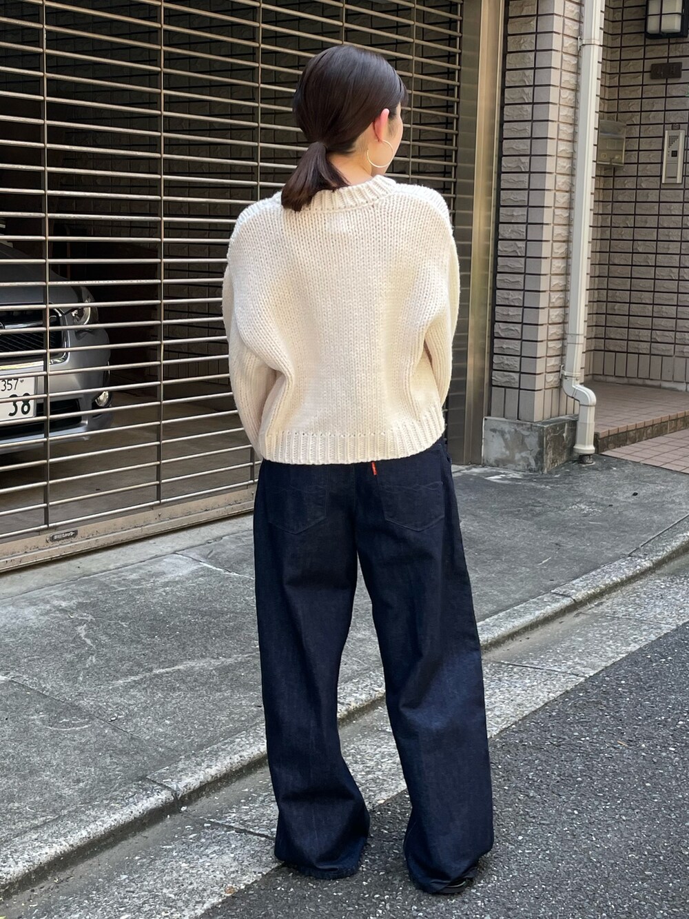 ブラック系のローファー、ブルー系のデニムパンツ、ホワイト系のカーディガン/ボレロを着用したレディースの秋コーディネートの4枚目の写真
