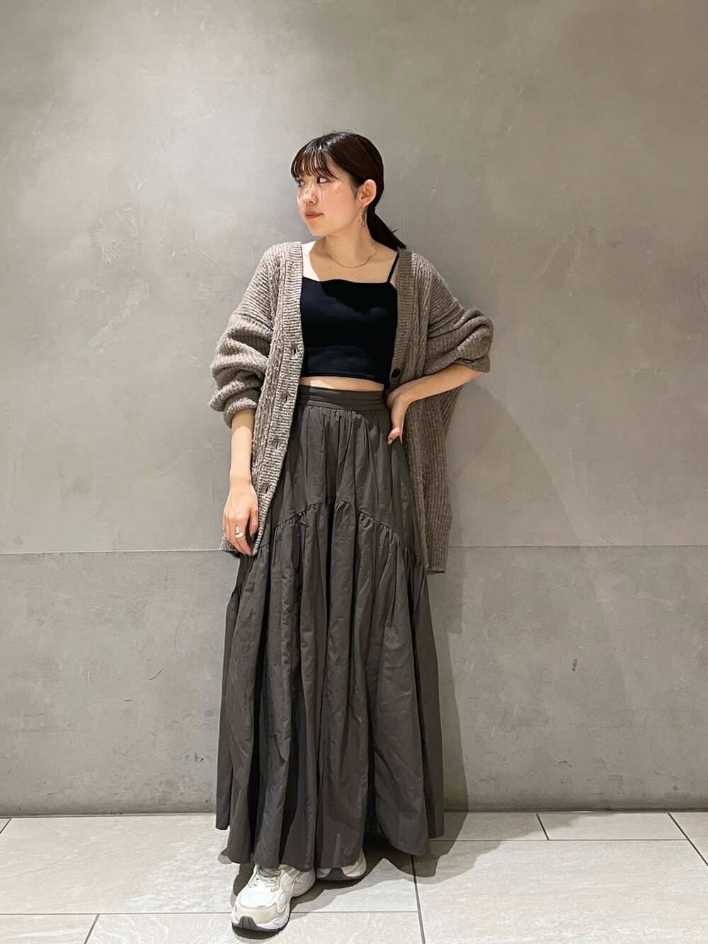 グレー系のカーディガン/ボレロ、グレー系のスカートを着用したレディースの秋コーディネートの5枚目の写真