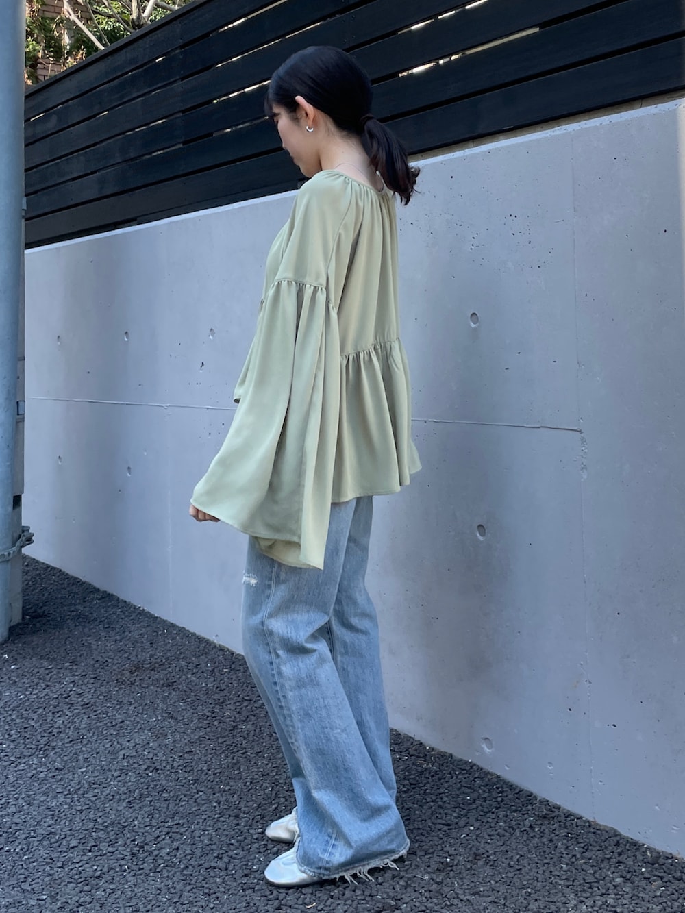 ブルー系のデニムパンツ、シルバー系のバレエシューズ、グリーン系のシャツ/ブラウスを着用したレディースの春コーディネートの3枚目の写真