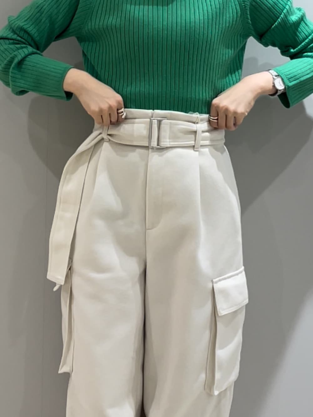 ブラック系のブーツ、ホワイト系のカーゴパンツ、グリーン系のニット/セーターを着用したレディースの冬コーディネートの7枚目の写真