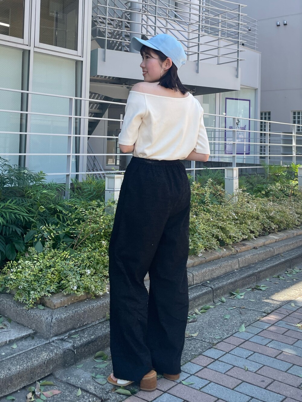 ホワイト系のサンダル、ブラック系のその他パンツ、ホワイト系のTシャツ/カットソーを着用したレディースの夏コーディネートの2枚目の写真