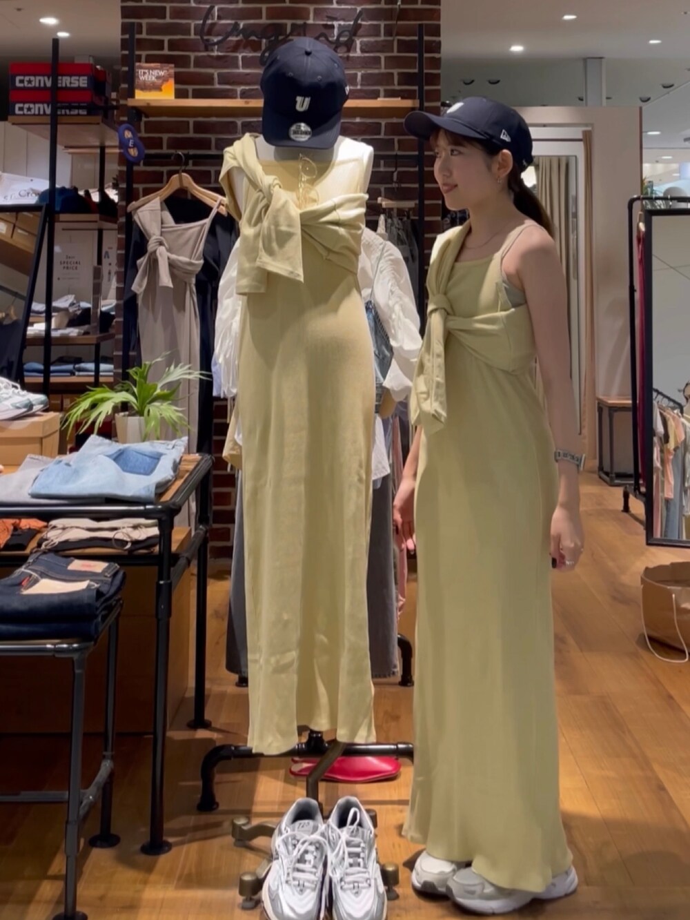 イエロー系のワンピース、ブルー系のキャップを着用したレディースの夏コーディネートの3枚目の写真