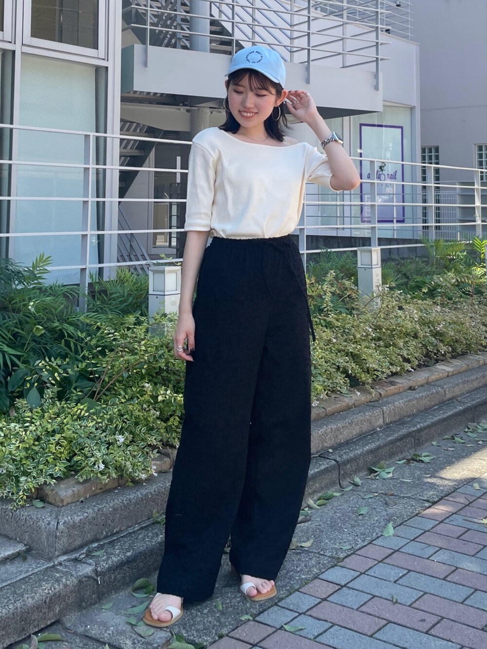 ホワイト系のサンダル、ブラック系のその他パンツ、ホワイト系のTシャツ/カットソーを着用したレディースの夏コーディネートの3枚目の写真