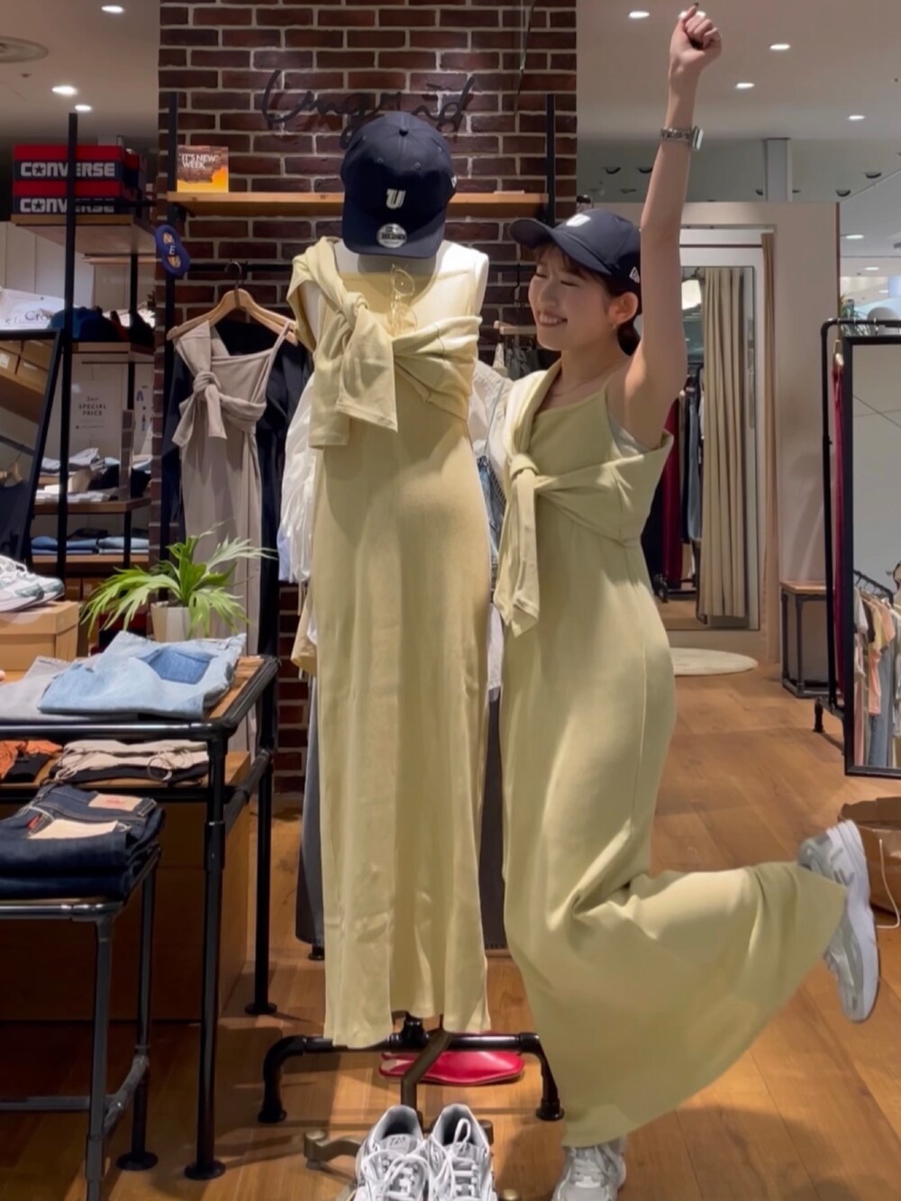 イエロー系のワンピース、ブルー系のキャップを着用したレディースの夏コーディネートの2枚目の写真