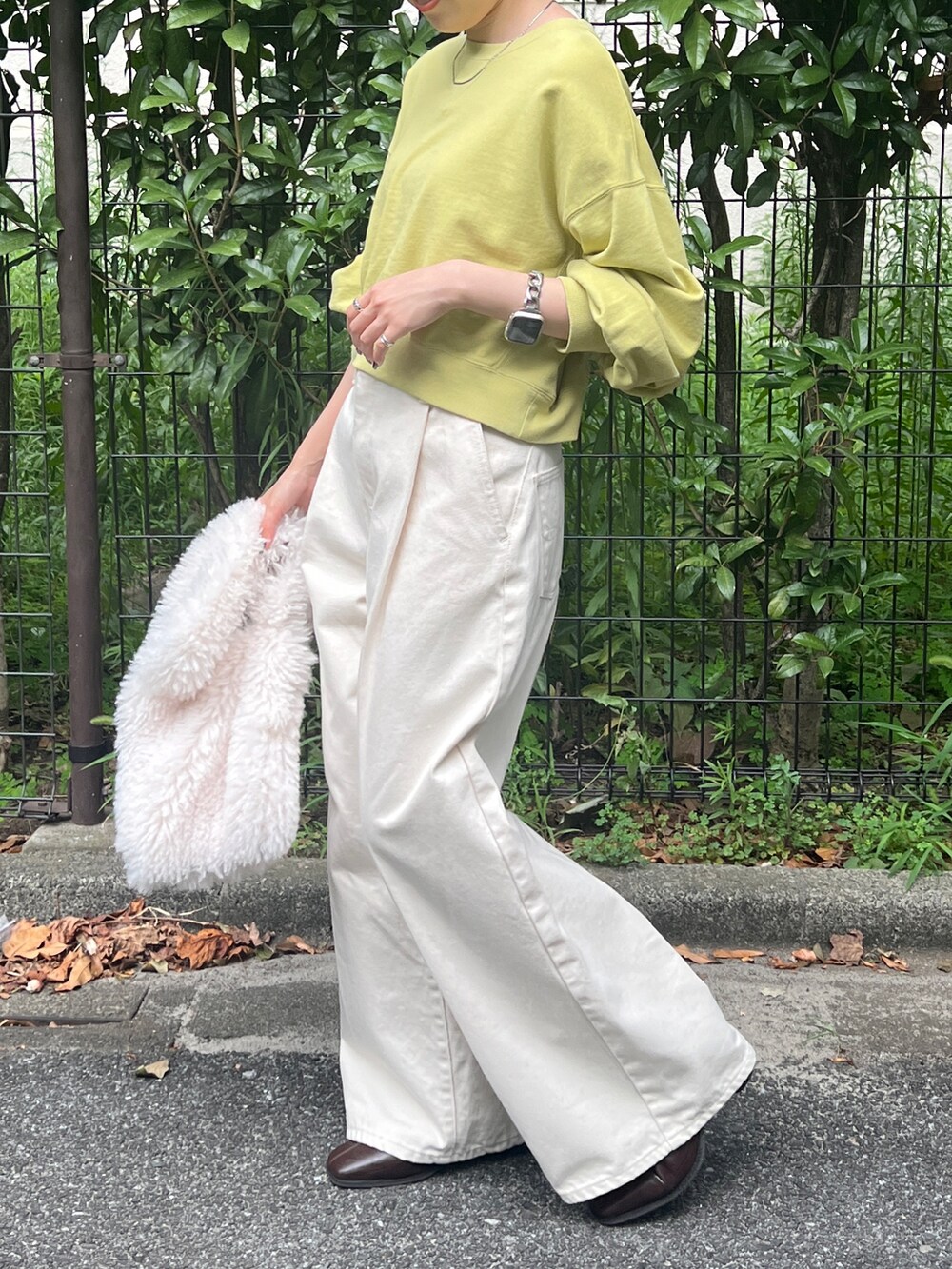 ホワイト系のデニムパンツ、ブラウン系のブーツ、グリーン系のスウェットを着用したレディースの秋コーディネートの3枚目の写真