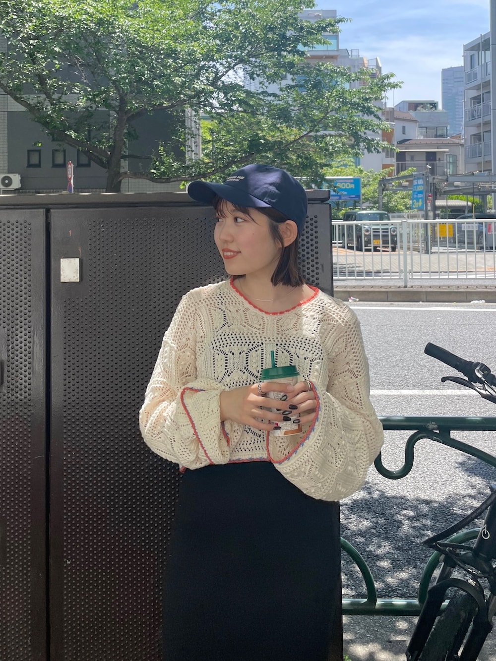 ブラック系のワンピース、ホワイト系のニット/セーター、ブルー系のキャップを着用したレディースの夏コーディネートの3枚目の写真