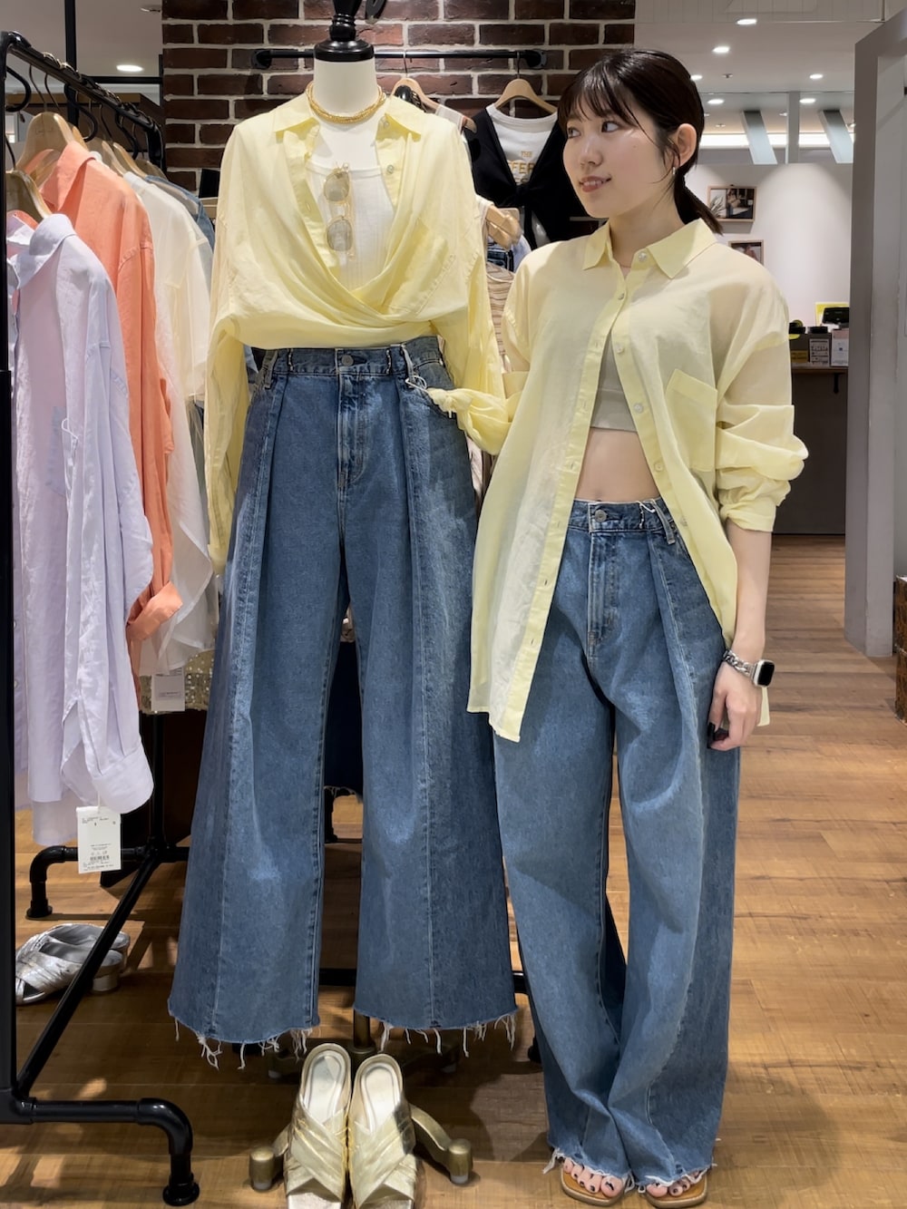 ブルー系のデニムパンツ、グレー系のキャミソール、ホワイト系のサンダルを着用したレディースの春コーディネートの5枚目の写真