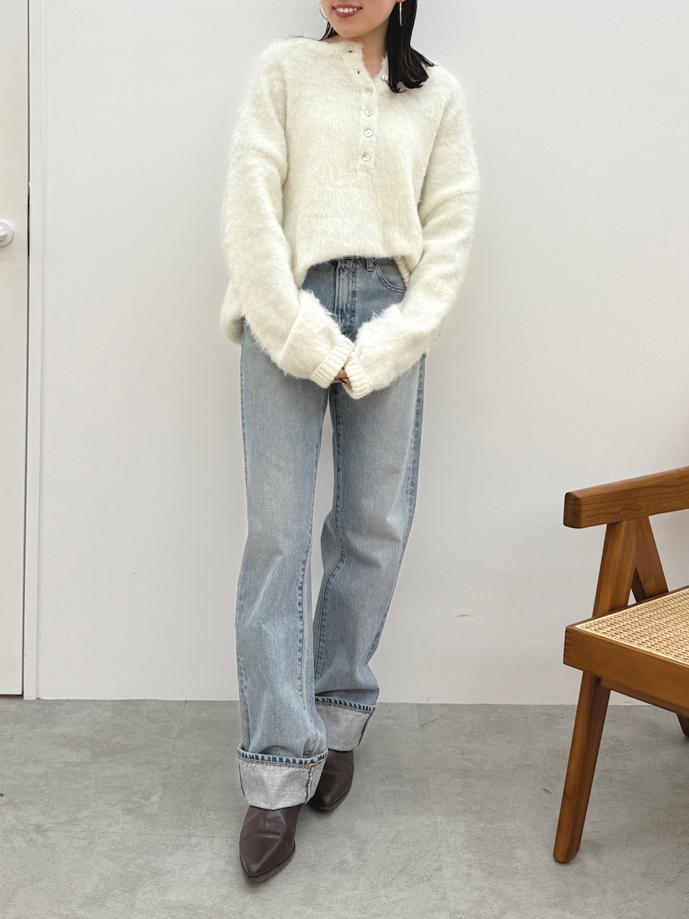 ホワイト系のニット/セーター、ブルー系のデニムパンツ、ブラウン系のブーツを着用したレディースの冬コーディネートの2枚目の写真