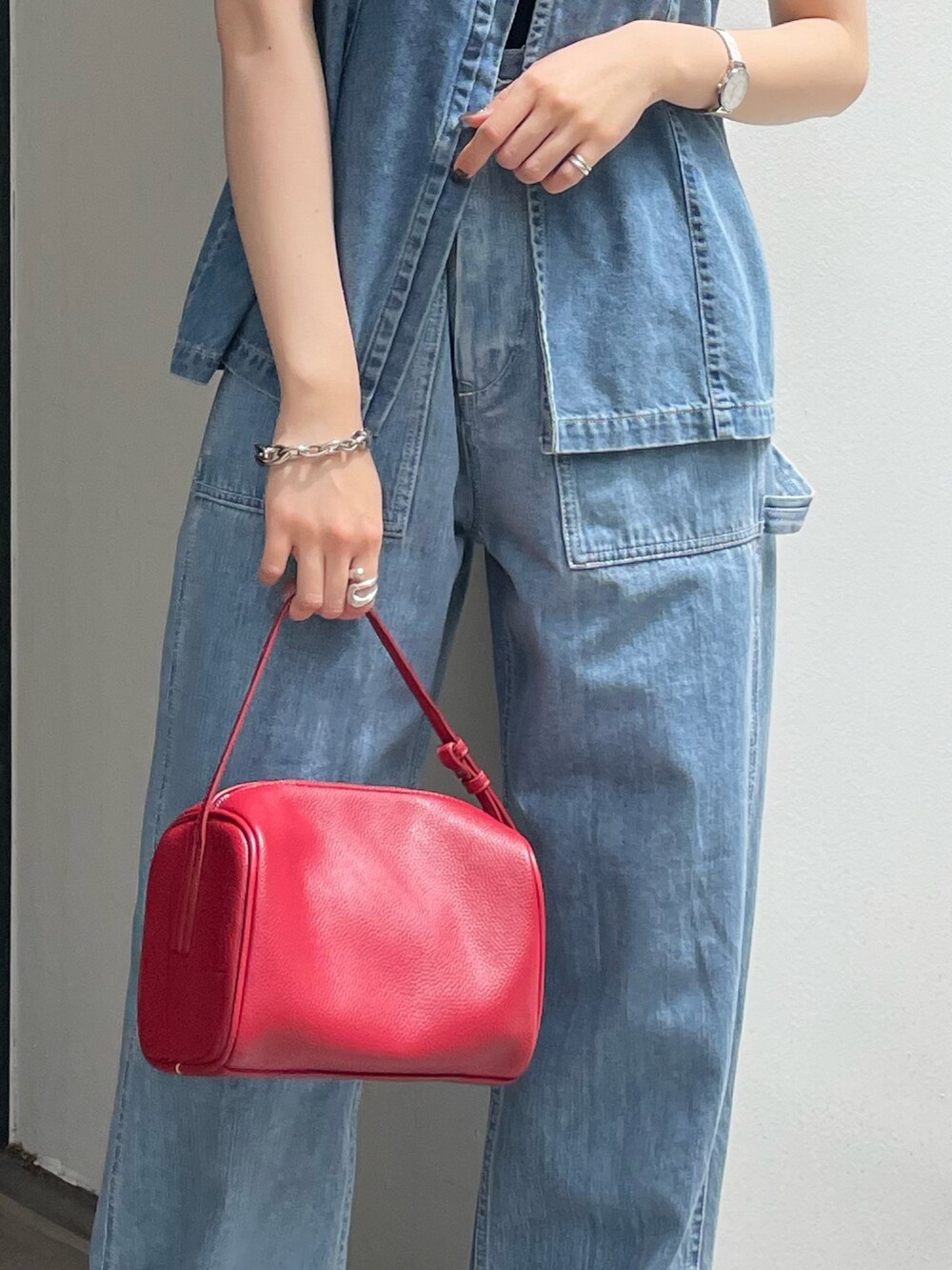 レッド系のハンドバッグ、ホワイト系のサンダル、ブルー系のキャミソールを着用したレディースの春コーディネートの6枚目の写真