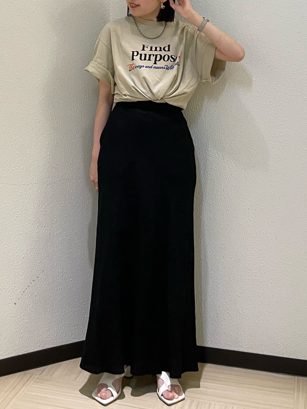 ホワイト系のサンダル、ベージュ系のTシャツ/カットソー、ブラック系のスカートを着用したレディースの春コーディネートの6枚目の写真