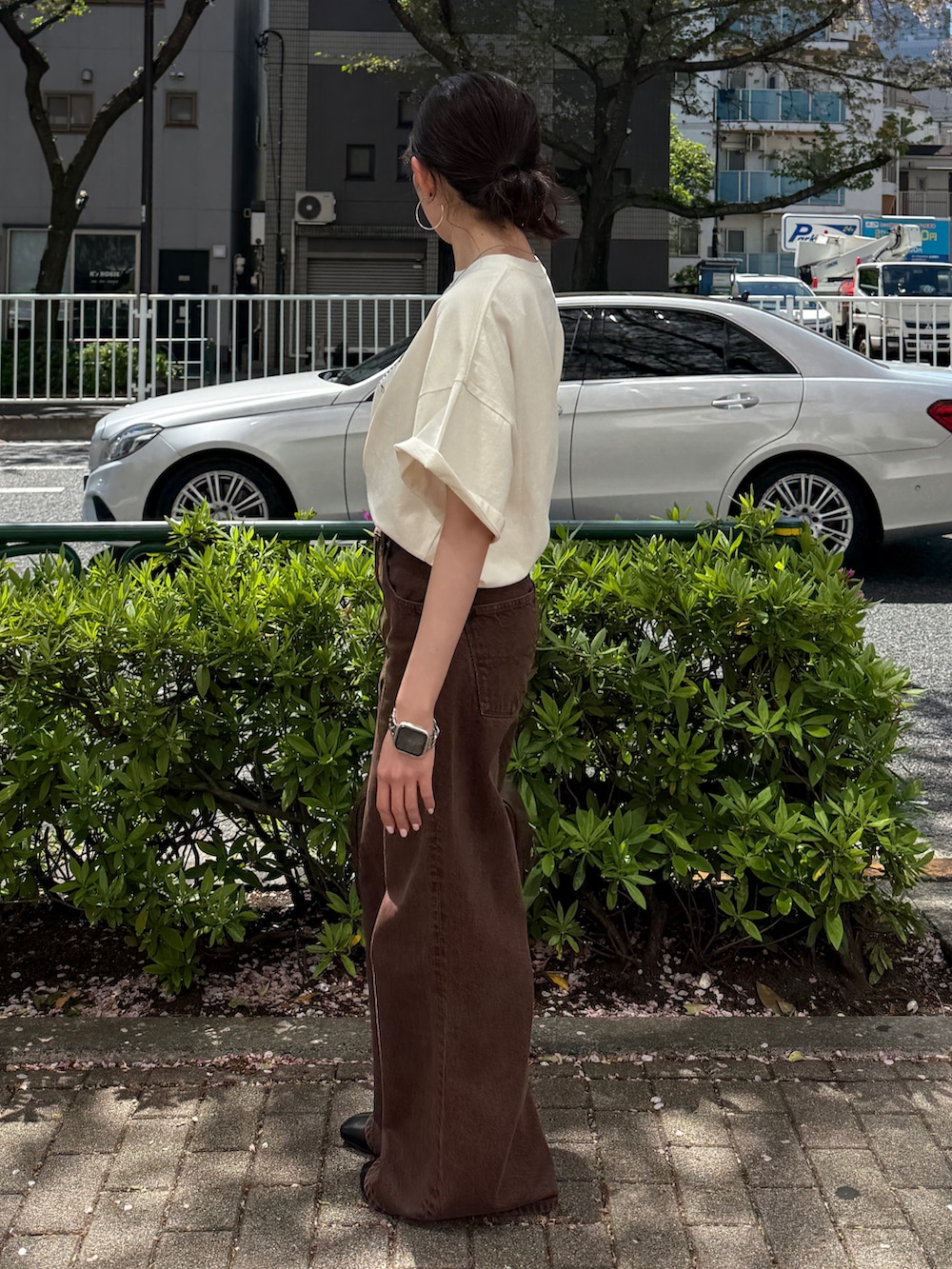 ホワイト系のTシャツ/カットソー、ブラウン系のデニムパンツ、ブラック系のサンダルを着用したレディースの春コーディネートの3枚目の写真