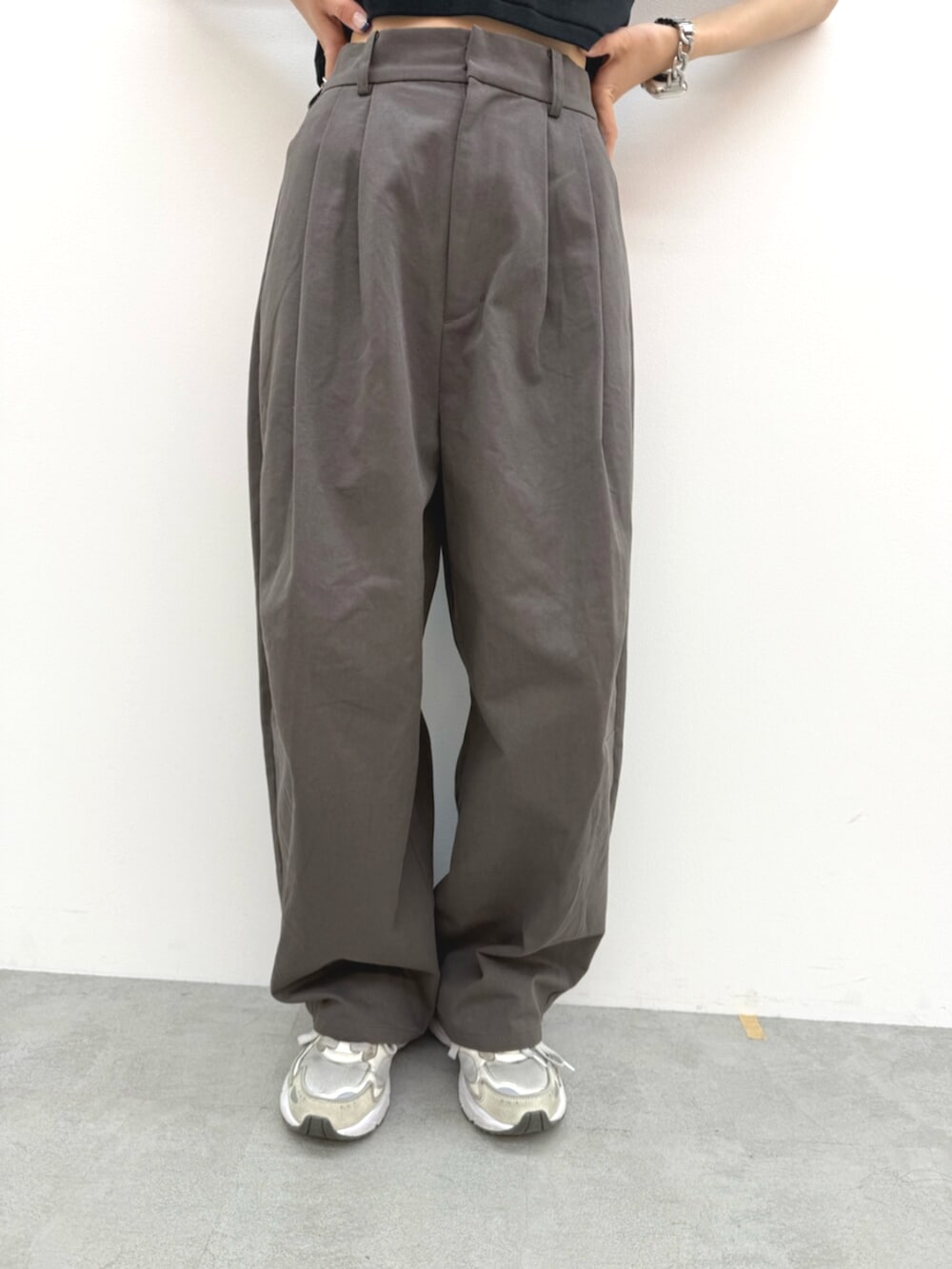 ブラック系のTシャツ/カットソー、グレー系のチノパンツ、ホワイト系のキャップを着用したレディースの春コーディネートの5枚目の写真