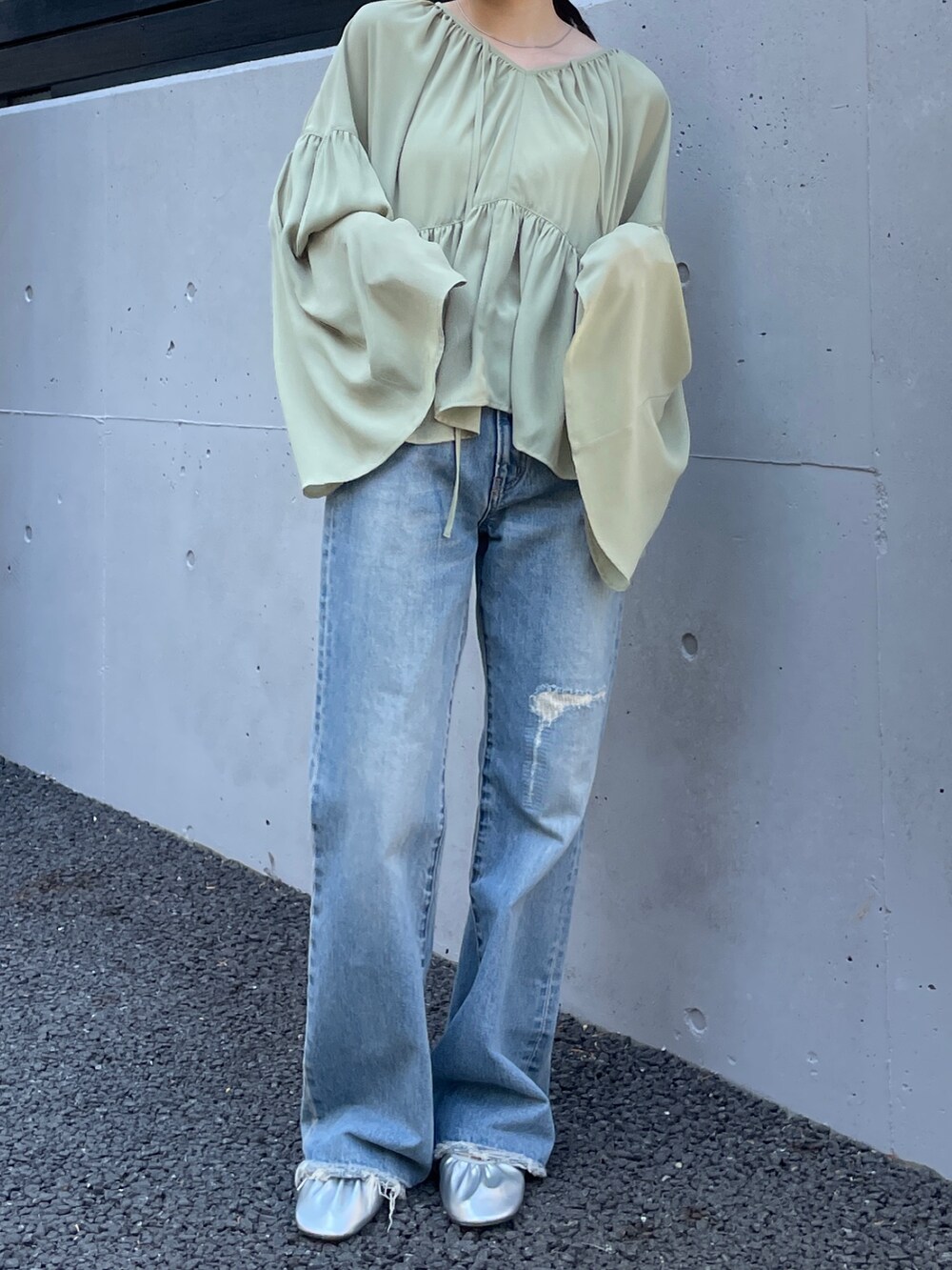 ブルー系のデニムパンツ、シルバー系のバレエシューズ、グリーン系のシャツ/ブラウスを着用したレディースの春コーディネートの5枚目の写真