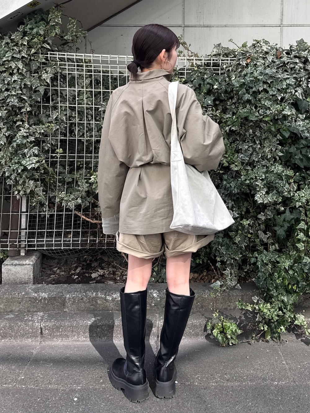 グリーン系のトレンチコート、ベージュ系のその他パンツを着用したレディースの冬コーディネートの3枚目の写真