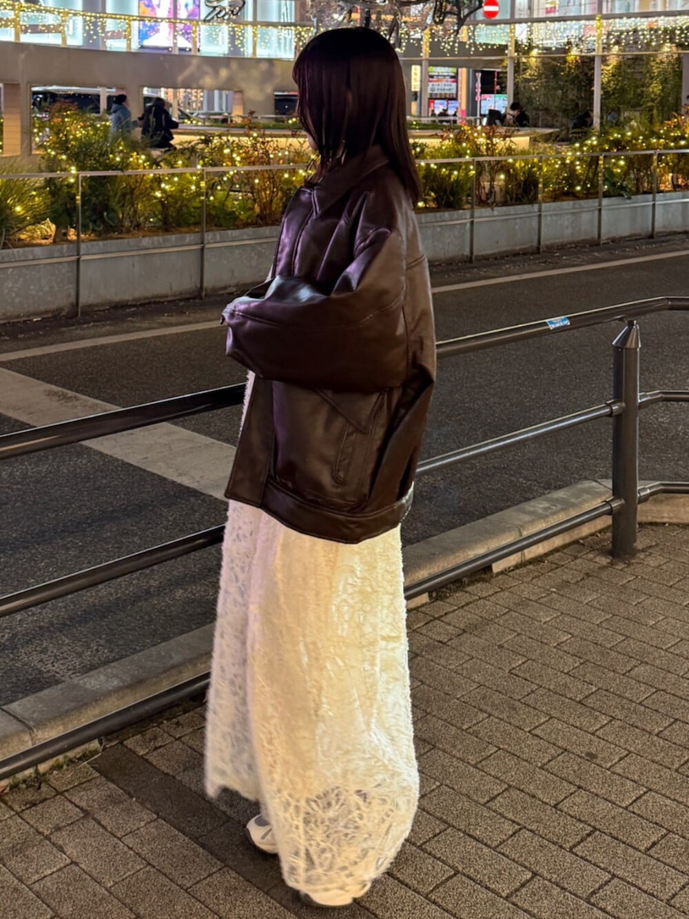 ブラウン系のハンドバッグ、ホワイト系のワンピース、ブラウン系のブルゾンを着用したレディースの冬コーディネートの5枚目の写真