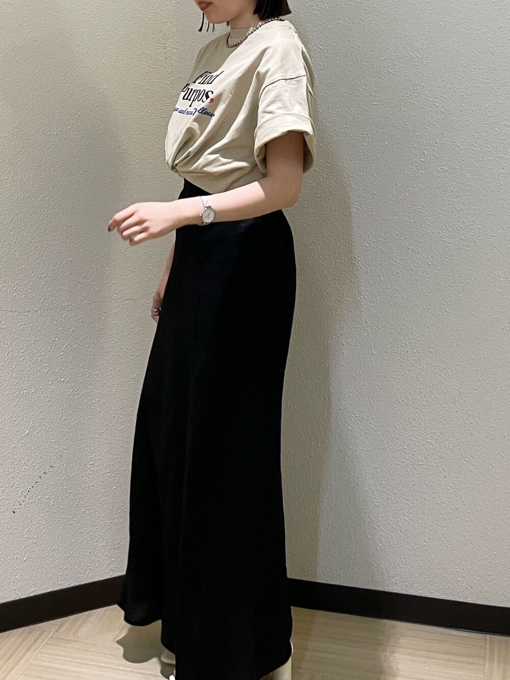 ホワイト系のサンダル、ベージュ系のTシャツ/カットソー、ブラック系のスカートを着用したレディースの春コーディネートの3枚目の写真