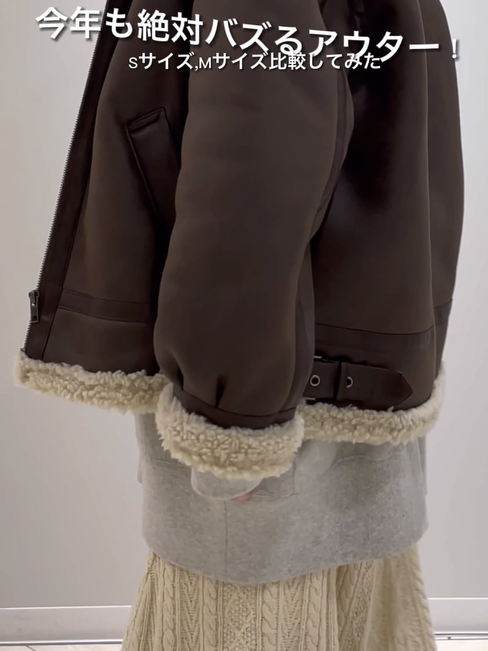 ブラウン系のムートンコート、グレー系のスウェット、ホワイト系のスカートを着用したレディースの秋コーディネートの5枚目の写真