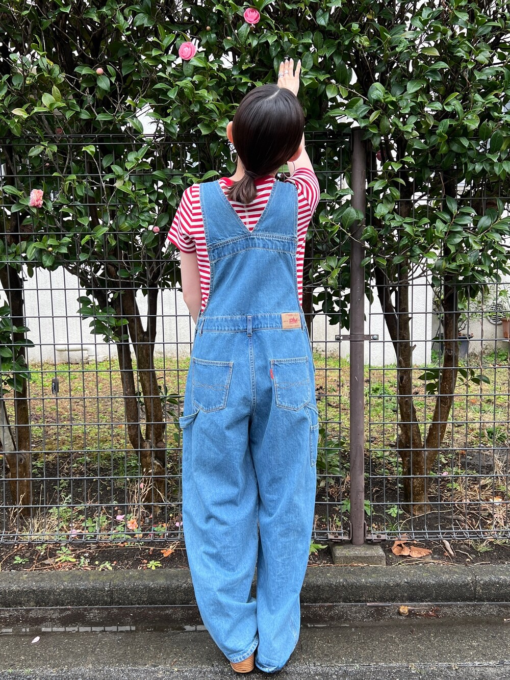 ブラック系のサンダル、ブルー系のつなぎ/オールインワン、レッド系のTシャツ/カットソーを着用したレディースの春コーディネートの3枚目の写真