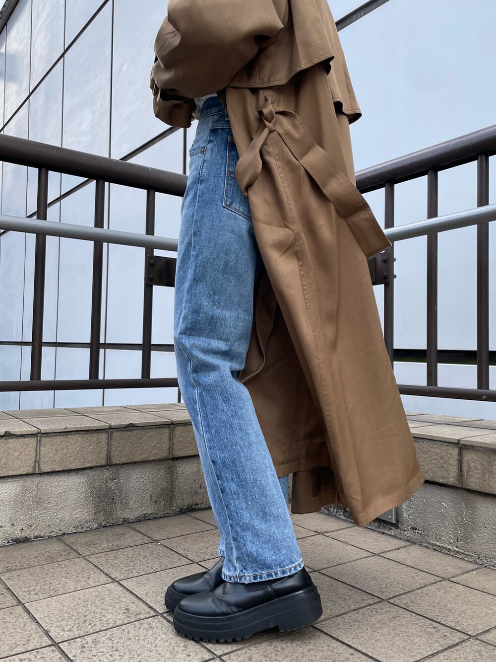 ホワイト系のハンドバッグ、ホワイト系のTシャツ/カットソー、ブルー系のデニムパンツを着用したレディースの冬コーディネートの8枚目の写真