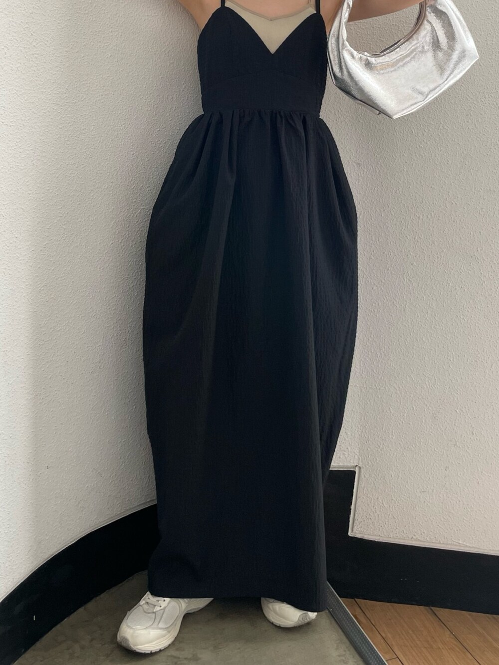 グレー系のキャミソール、シルバー系のハンドバッグ、ブラック系のワンピースを着用したレディースの春コーディネートの6枚目の写真