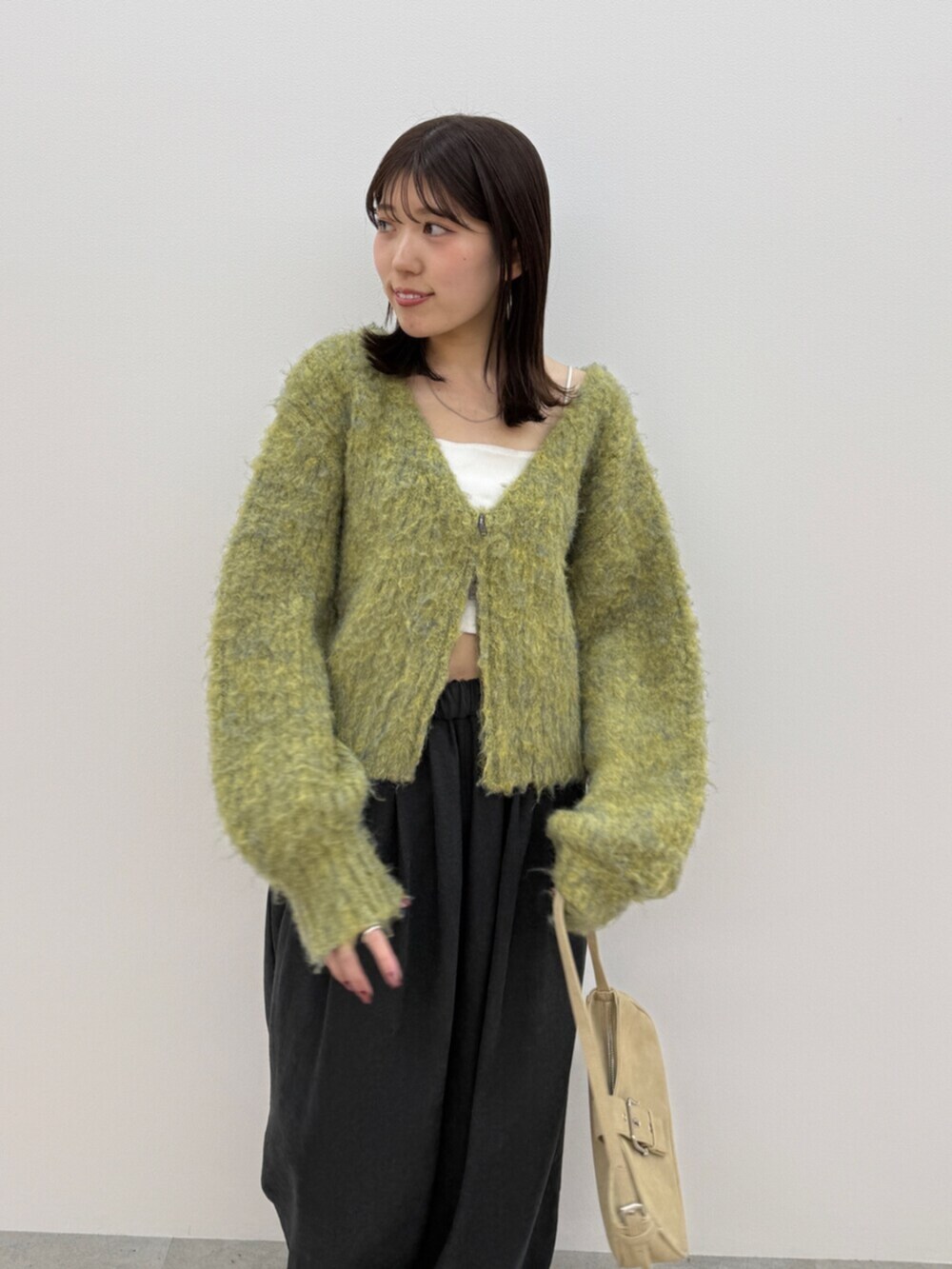 ベージュ系のハンドバッグ、ブラウン系のその他パンツ、イエロー系のニット/セーターを着用したレディースの秋コーディネートの6枚目の写真