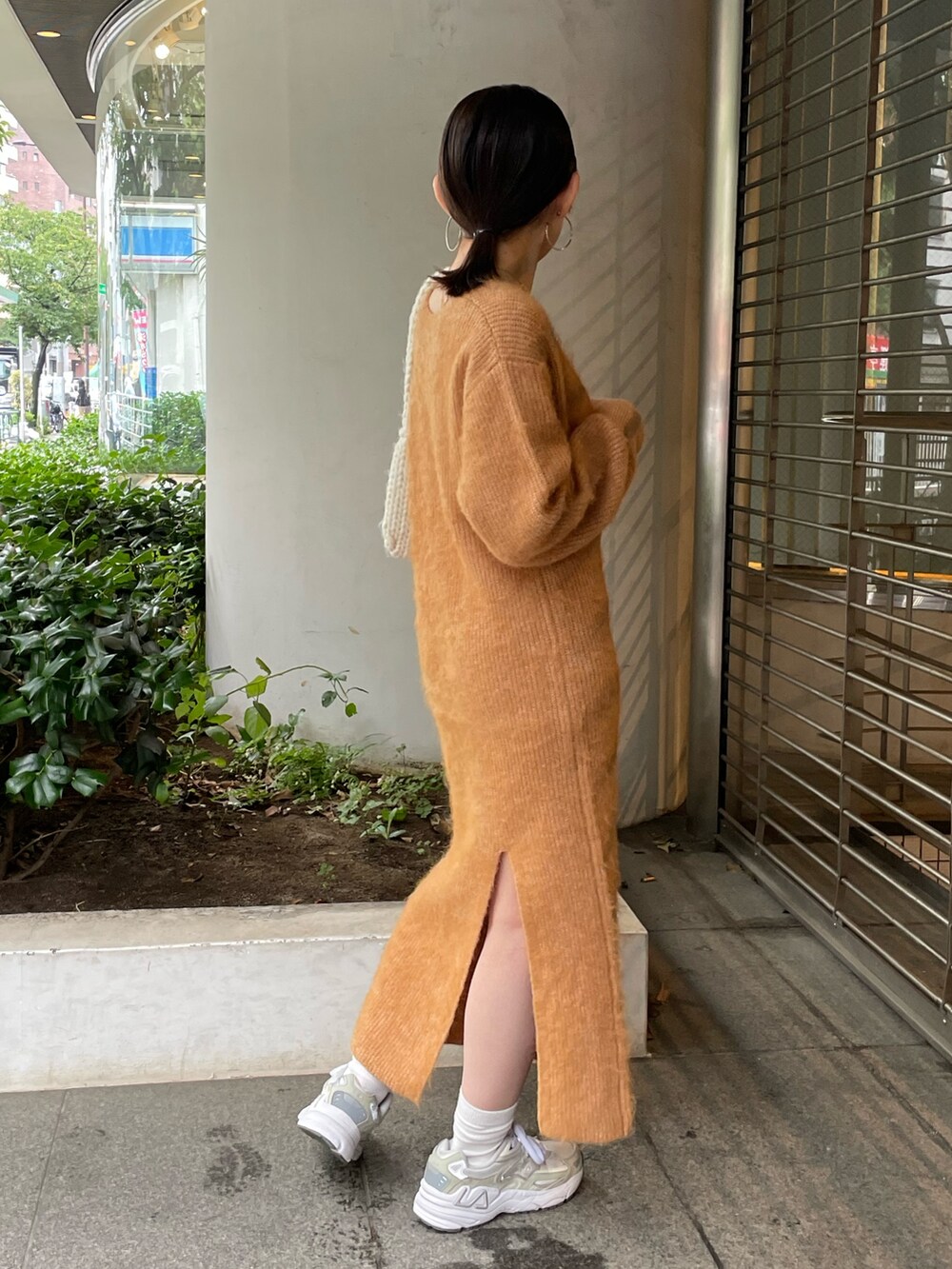 ホワイト系のハンドバッグ、オレンジ系のワンピースを着用したレディースの秋コーディネートの7枚目の写真