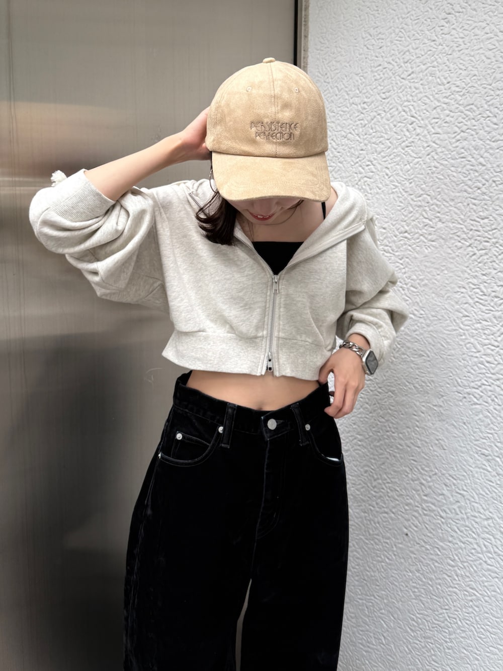 ホワイト系のパーカー、ブラック系のデニムパンツ、ベージュ系のキャップを着用したレディースの秋コーディネートの5枚目の写真