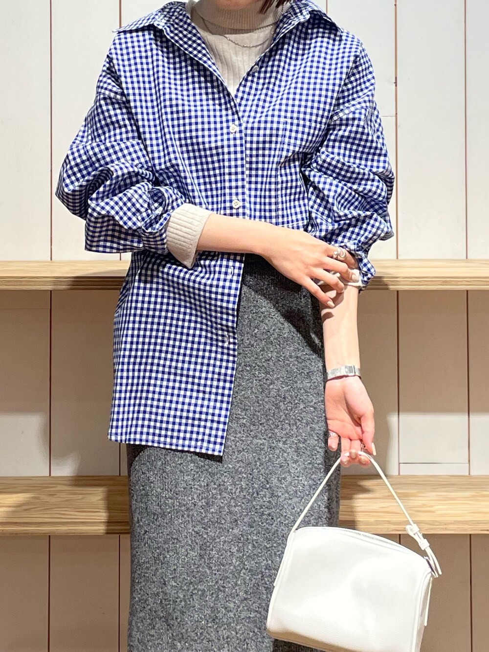 ホワイト系のハンドバッグ、ブルー系のシャツ/ブラウス、グレー系のスカートを着用したレディースの冬コーディネートの4枚目の写真