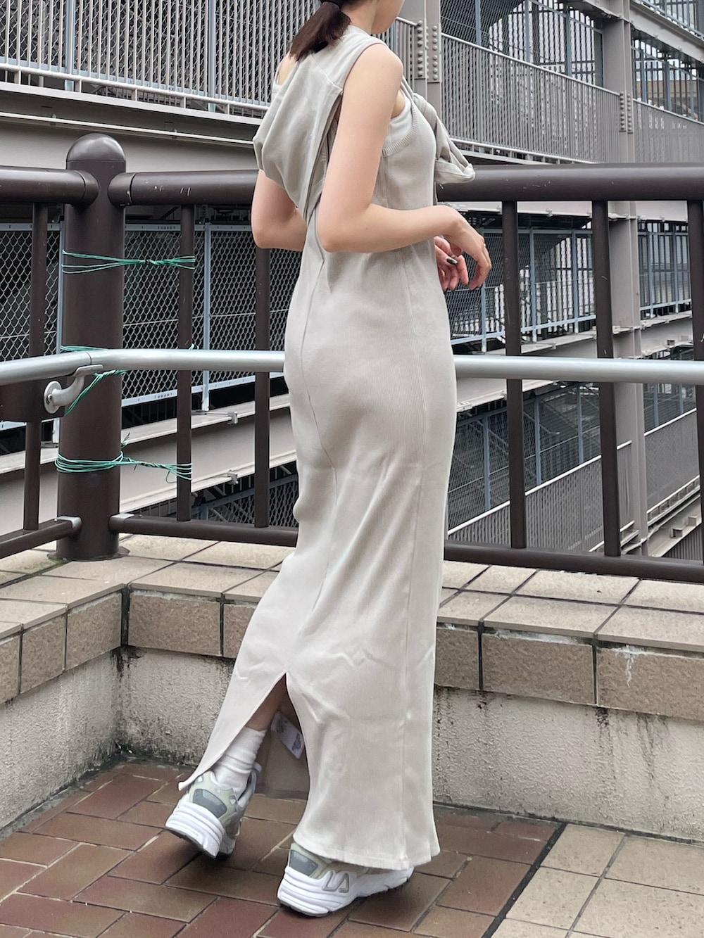 グレー系のワンピース、ブルー系のデニムジャケット、ブルー系のキャップを着用したレディースの夏コーディネートの4枚目の写真