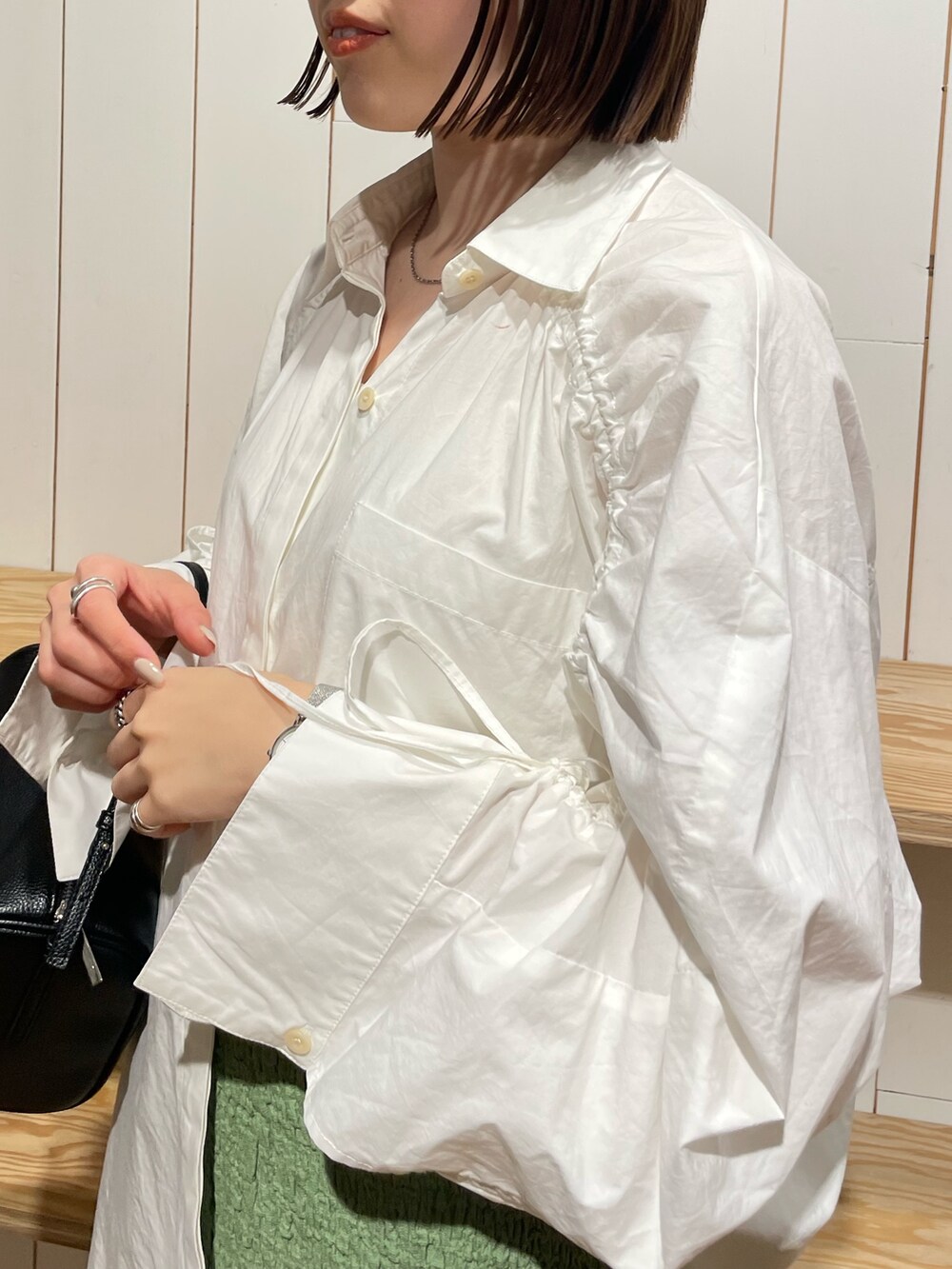 ブラック系のハンドバッグ、ブラック系のブーツ、ホワイト系のシャツ/ブラウスを着用したレディースの冬コーディネートの7枚目の写真