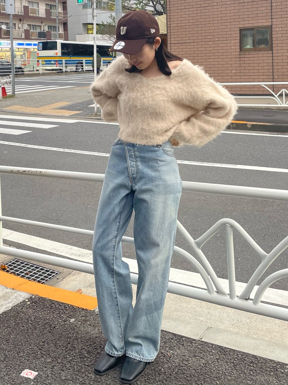 ブラック系のブーツ、ブルー系のデニムパンツ、ホワイト系のニット/セーターを着用したレディースの秋コーディネートの3枚目の写真