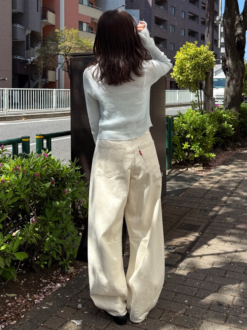 ブルー系のカーディガン/ボレロ、ホワイト系のデニムパンツ、ブラック系のハンドバッグを着用したレディースの春コーディネートの5枚目の写真
