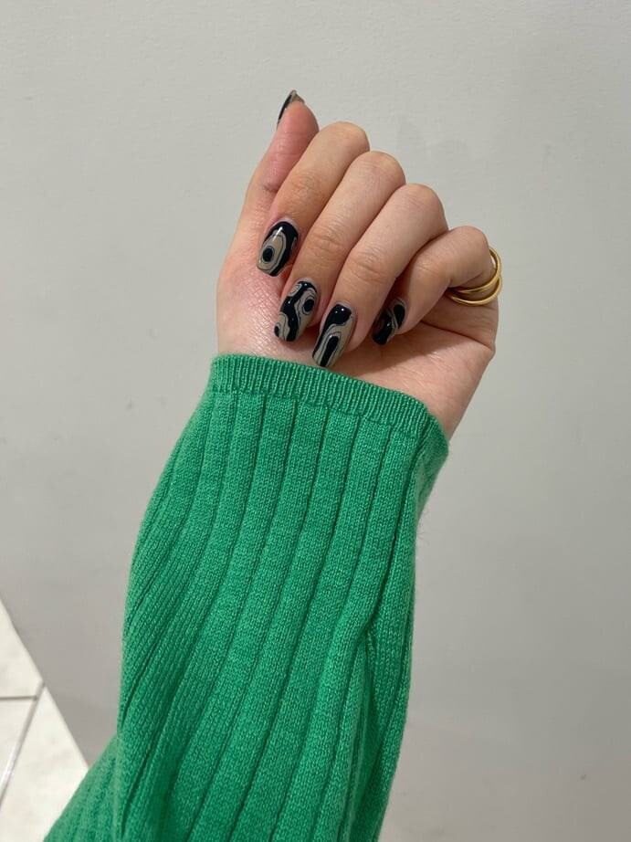 ホワイト系のハンドバッグ、グリーン系のニット/セーター、ブラック系のスカートを着用したレディースの秋コーディネートの6枚目の写真