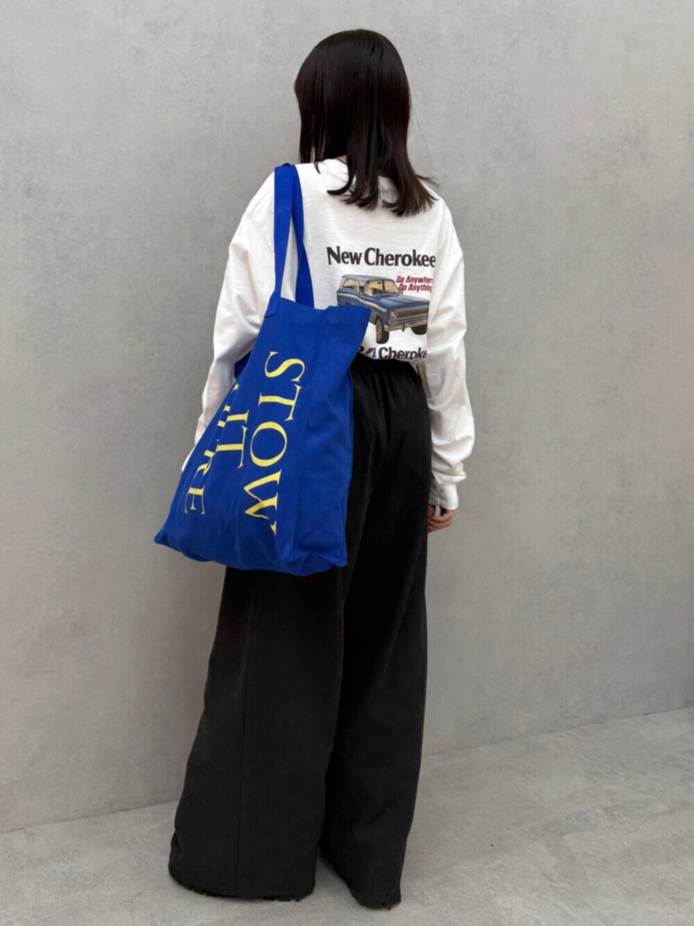 グレー系のその他パンツ、ブルー系のトートバッグ、ホワイト系のTシャツ/カットソーを着用したレディースの秋コーディネートの4枚目の写真