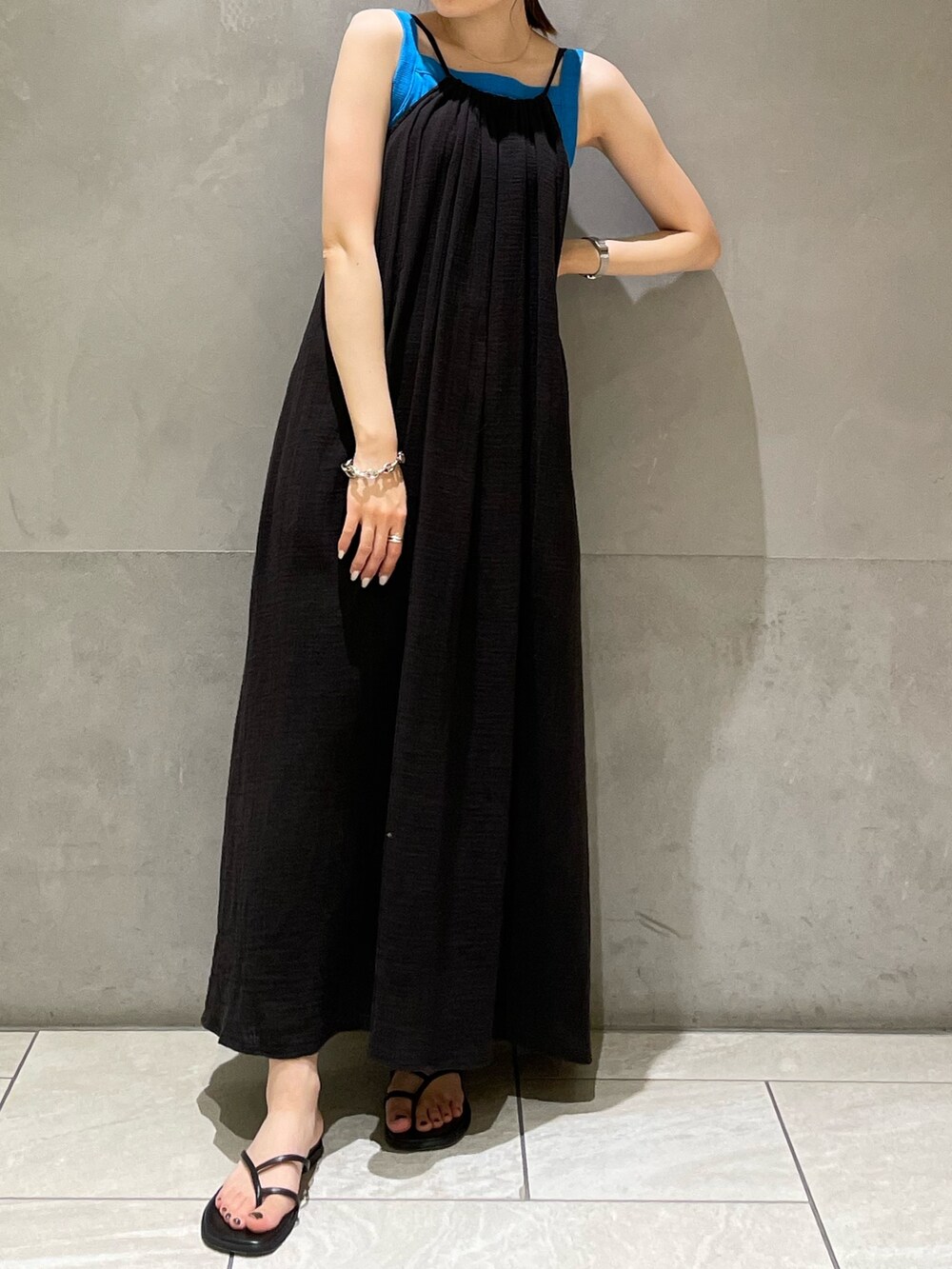 ブルー系のタンクトップ、ブラック系のワンピース、ブラック系のサンダルを着用したレディースの夏コーディネートの2枚目の写真