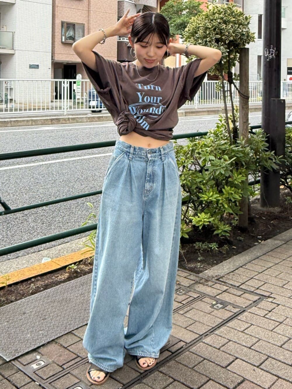 ブラック系のサンダル、ブルー系のデニムパンツ、ブラウン系のTシャツ/カットソーを着用したレディースの夏コーディネートの5枚目の写真