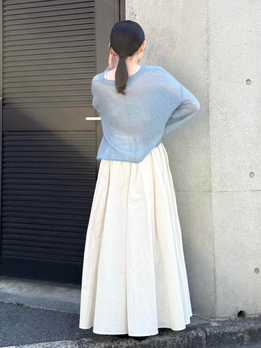 ホワイト系のスカート、ブラウン系のブーツ、ブルー系のニット/セーターを着用したレディースの秋コーディネートの4枚目の写真