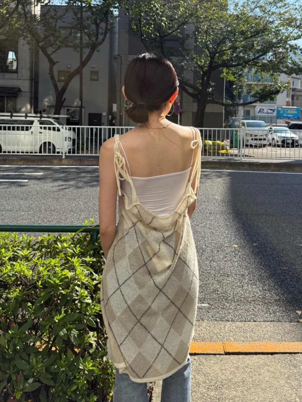 ブラウン系のブーツ、ホワイト系のハンドバッグ、ブルー系のデニムパンツを着用したレディースの秋コーディネートの7枚目の写真