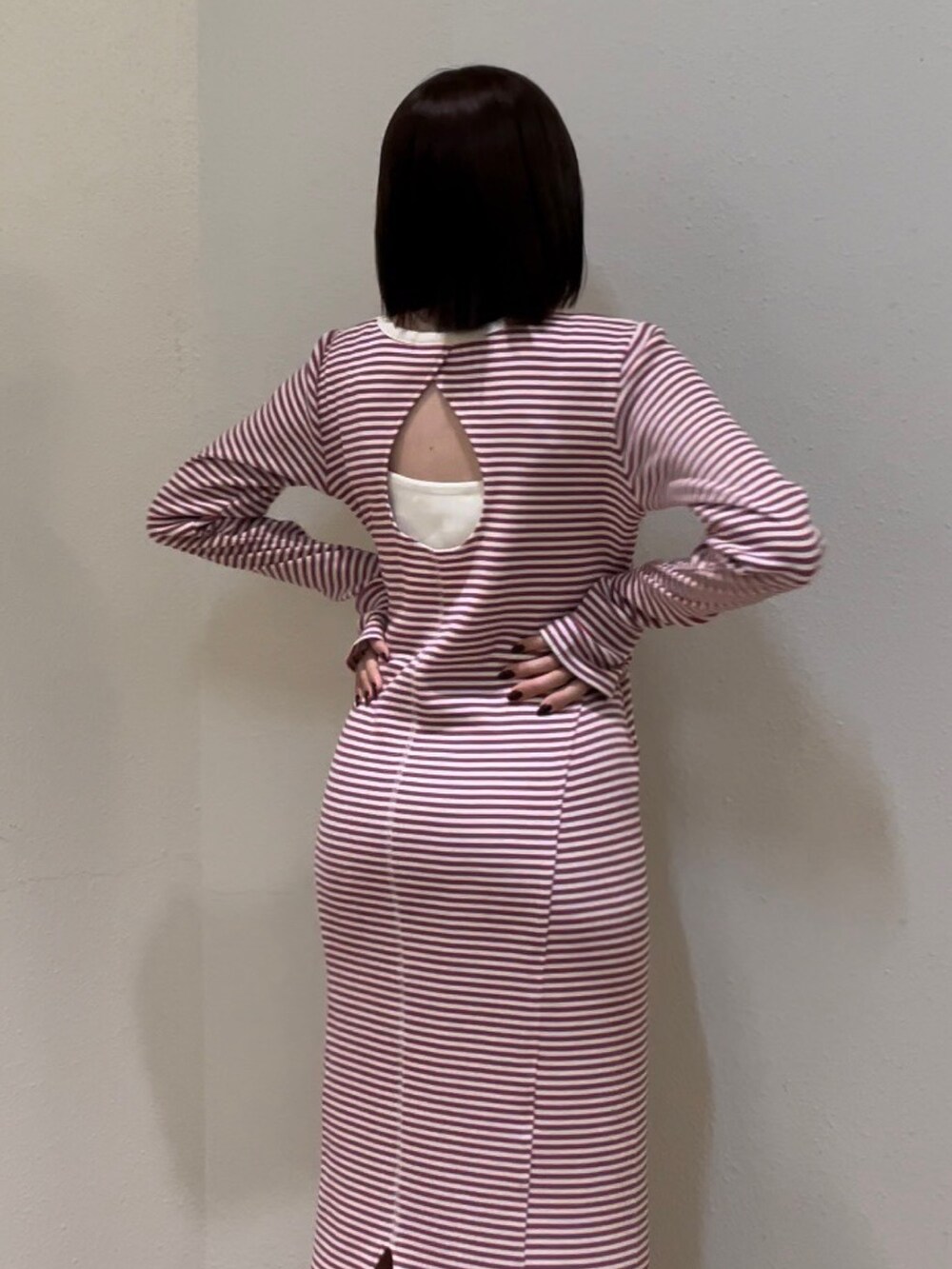 レッド系のワンピース、ホワイト系のシャツ/ブラウス、シルバー系のネックレスを着用したレディースの春コーディネートの6枚目の写真