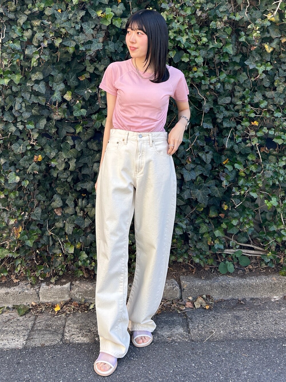 ピンク系のTシャツ/カットソー、ホワイト系のデニムパンツ、ホワイト系のサンダルを着用したレディースの春コーディネートの2枚目の写真