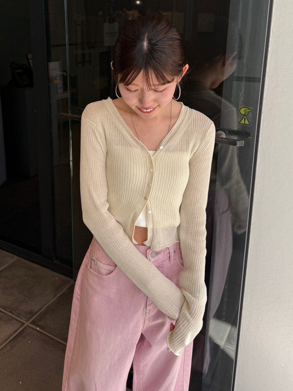 ピンク系のデニムパンツ、ブラック系のサンダル、ホワイト系のカーディガン/ボレロを着用したレディースの春コーディネートの5枚目の写真