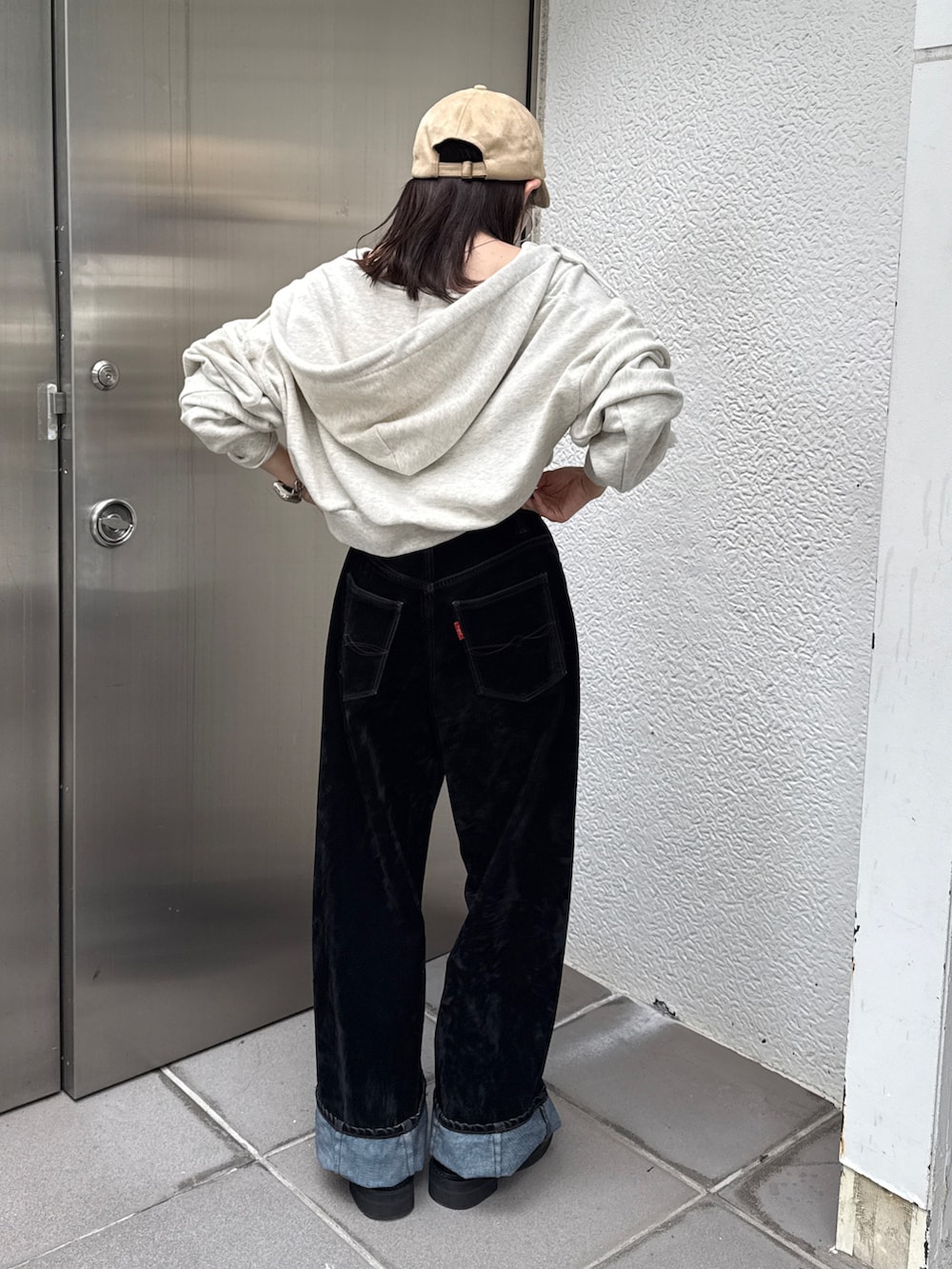 ホワイト系のパーカー、ブラック系のデニムパンツ、ベージュ系のキャップを着用したレディースの秋コーディネートの6枚目の写真