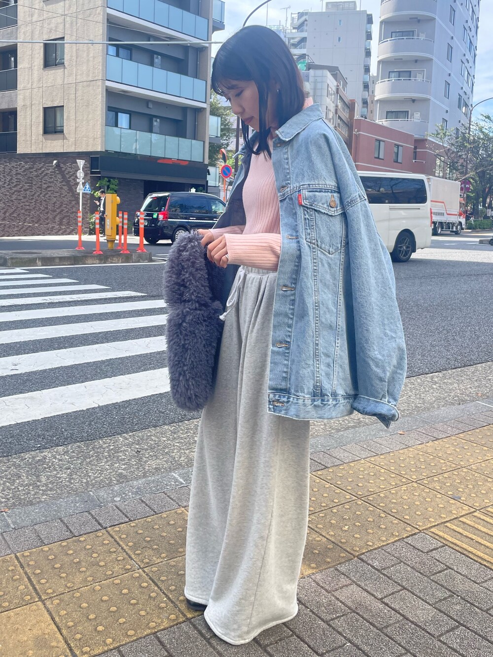 ピンク系のニット/セーター、グレー系のハンドバッグ、グレー系のスウェットパンツを着用したレディースの秋コーディネートの4枚目の写真